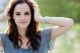 A beautiful young woman posing for a picture in a field.