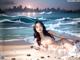 A woman laying on a beach next to the ocean.