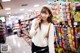 A woman standing in a grocery store holding a bag of candy.