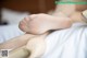 A close up of a woman's feet in high heels on a bed.